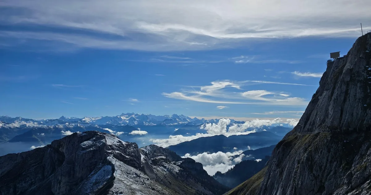 Felswände über einem Wolkenmeer, am Horizont die Alpen