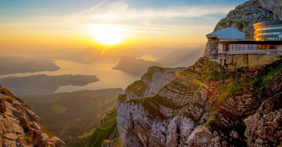 Sonnenuntergang über dem Vierwaldstättersee vom Gipfel aus, mit dem Hotel an der Felskante